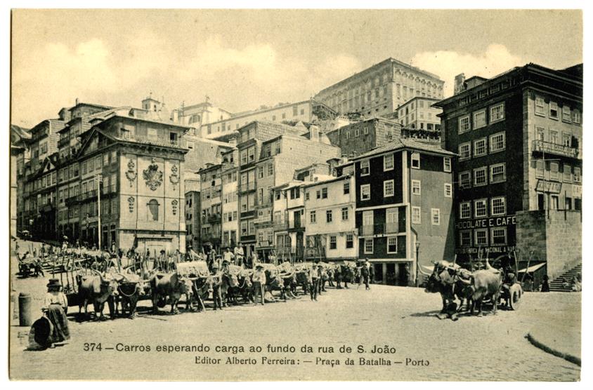 Carros esperando carga ao fundo da rua de São João