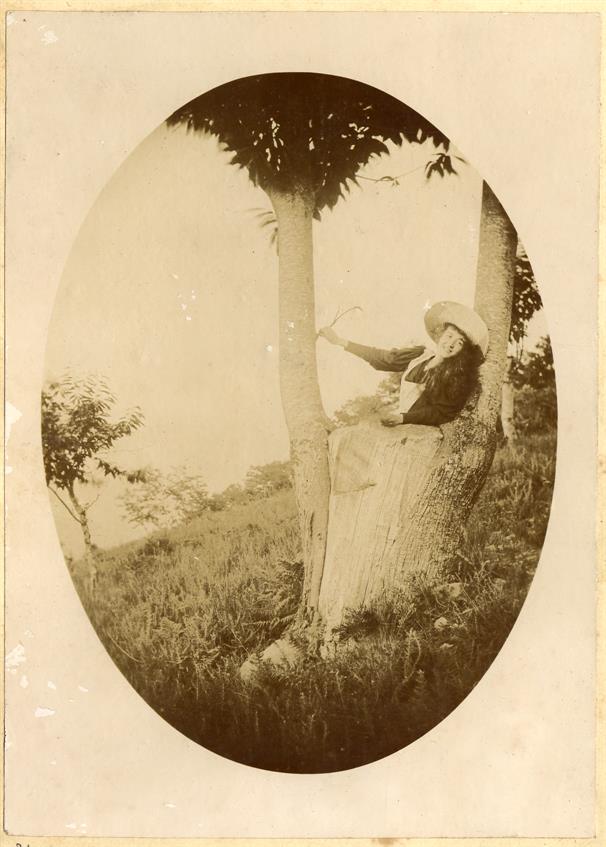 Mulher encostada a uma árvore